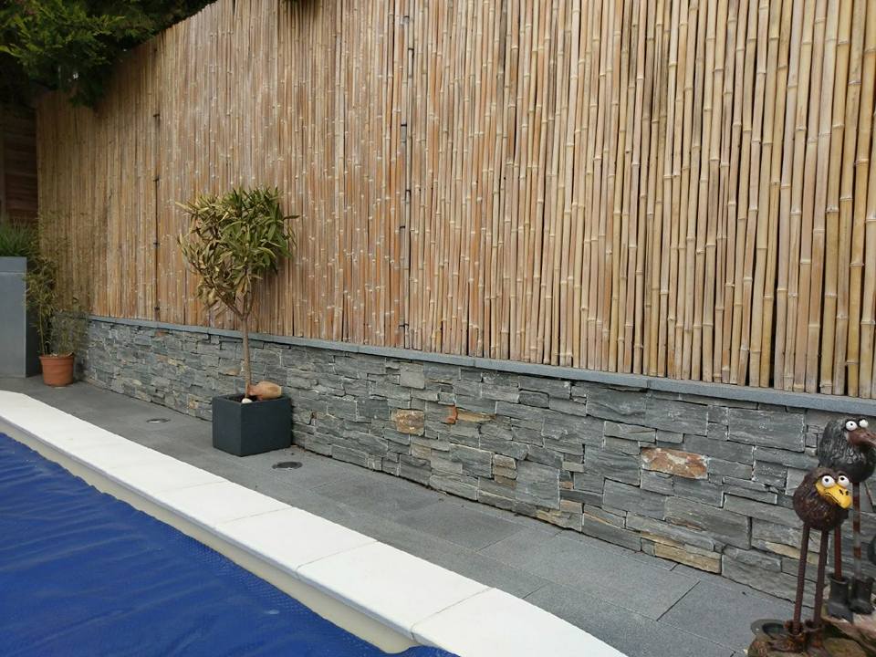 Sichtschutzgestaltung mit Bambusstäben und Natursteinen im Aussenbereich