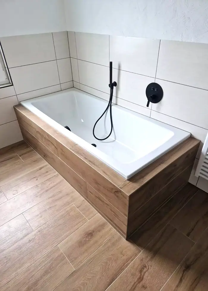 Badewanne wurde umrandet mit Fliesen in Holzoptik verlegt