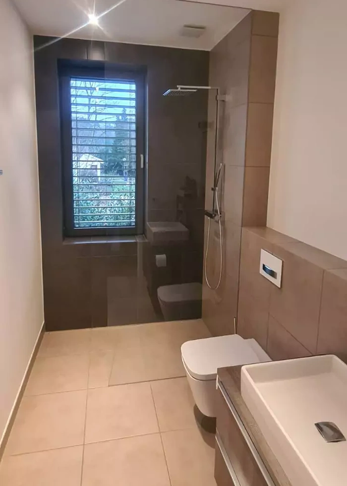 Ein Badezimmer mit Waschbecken, Toilette und begehbarer Duschkabine