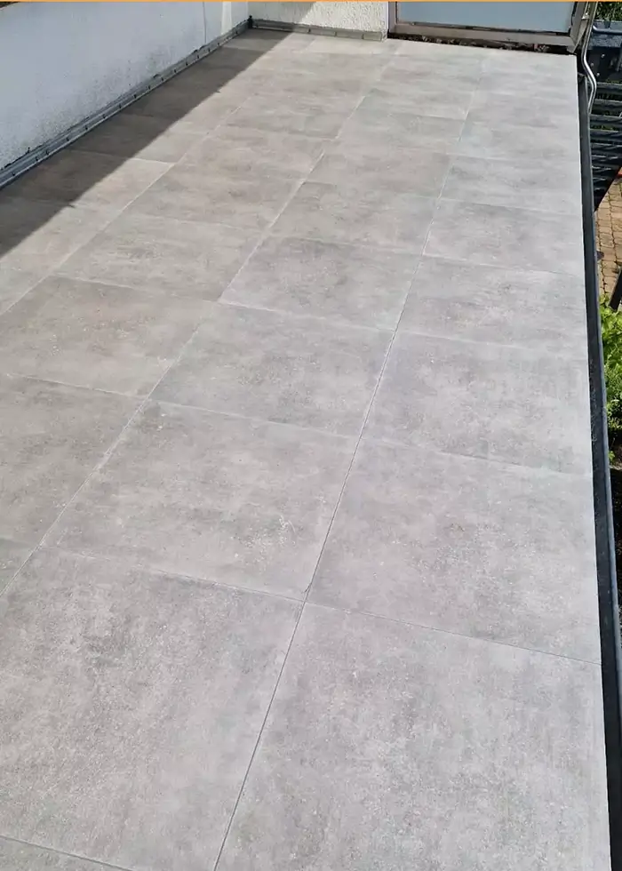 Moderner großer Balkon wurde mit grauen Steinfliesen ausgelegt