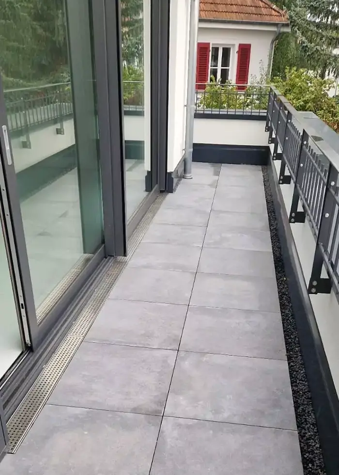 Moderner großer Balkon wurde mit grauen Steinfliesen ausgelegt