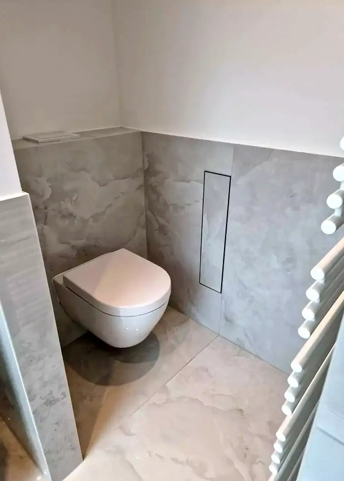 Grau gefliestes Badezimmer mit weißer schwebender Toilette