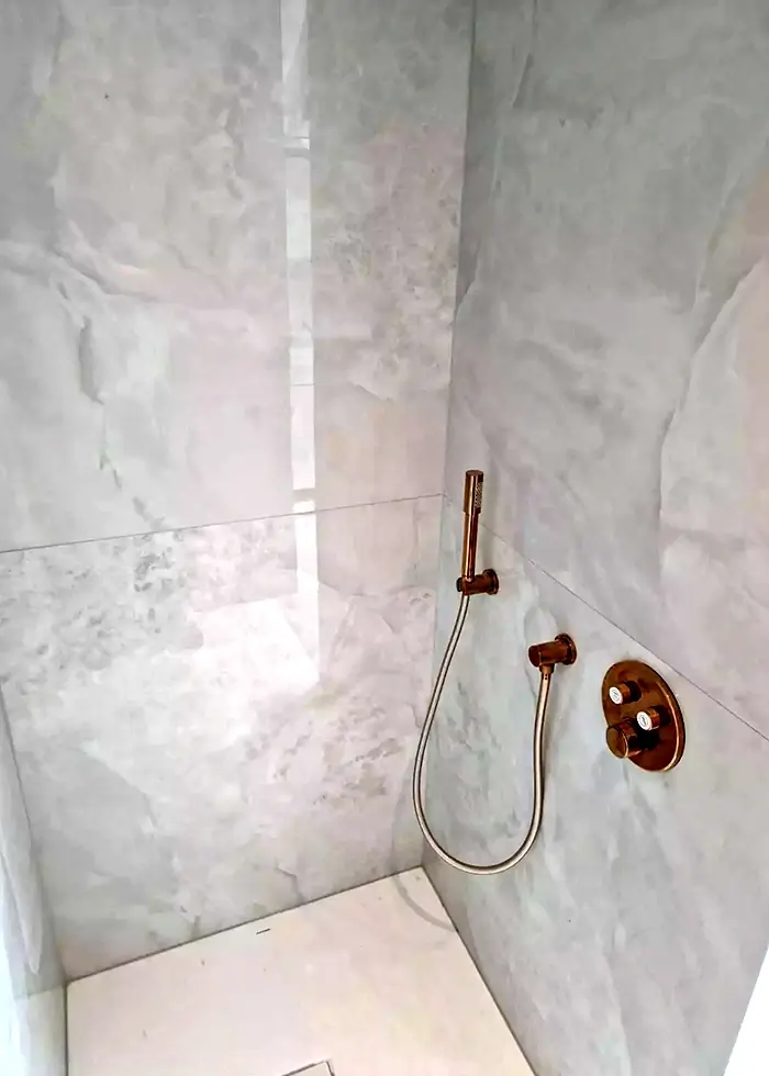Grau gefliestes Badezimmer mit einer begehbaren Duschkabine
